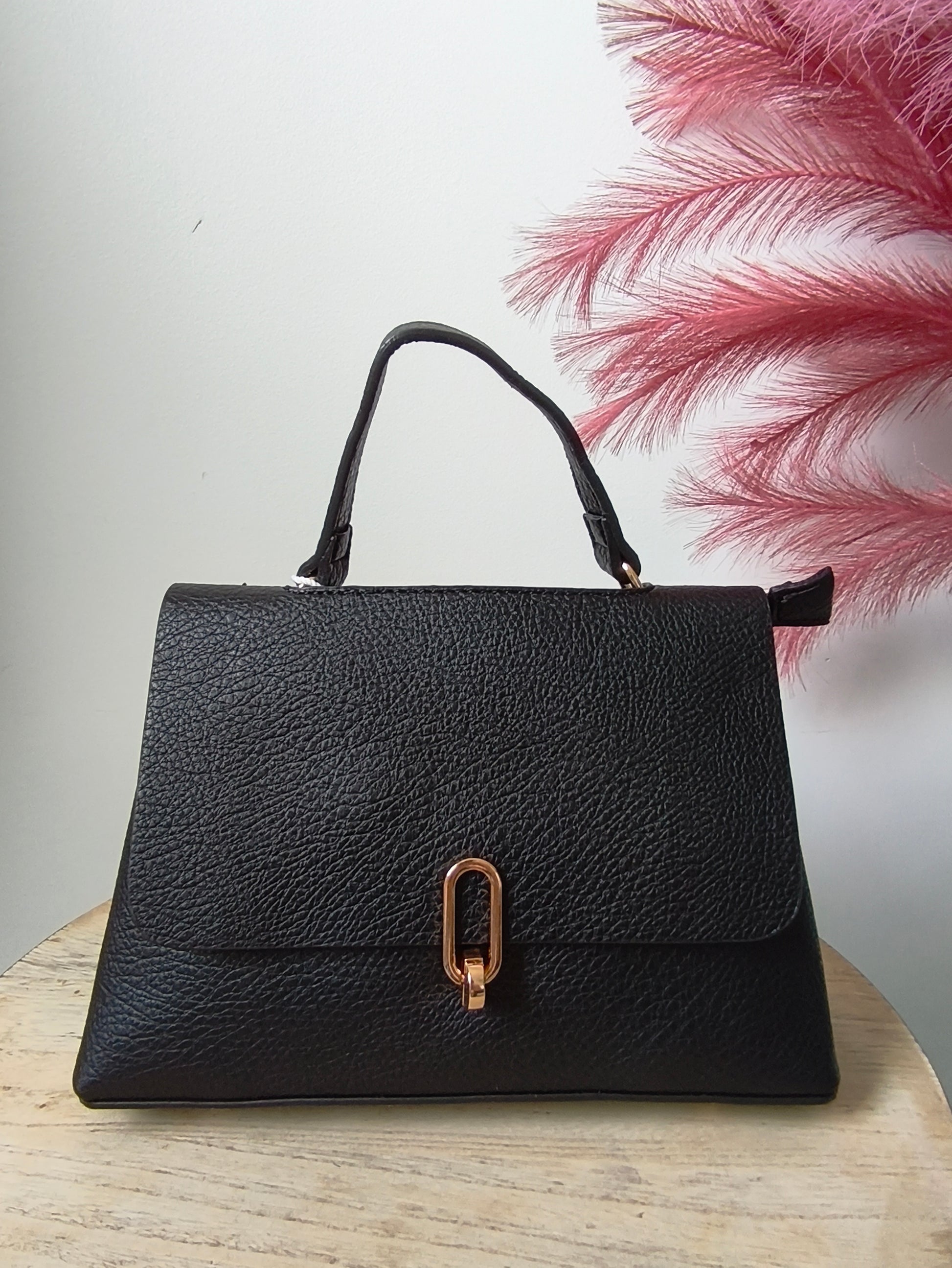 sac à main classique noir avec détail doré. peut se porter aussi en bandoulière